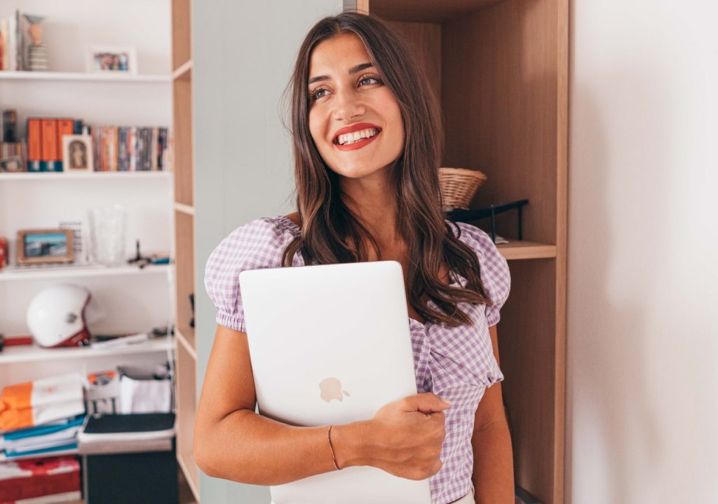 Foto che ritrae Arianna Cavina mentre tiene il suo laptop tra le mani